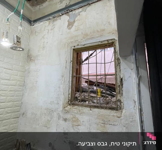 קיר מתקלף עם חלון וסולם עץ